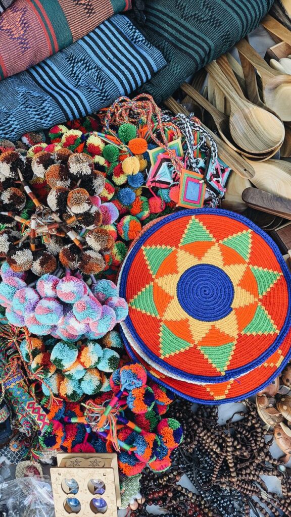 Colorful handcrafted items on display at Riohacha market in Colombia, featuring woven crafts and unique designs.